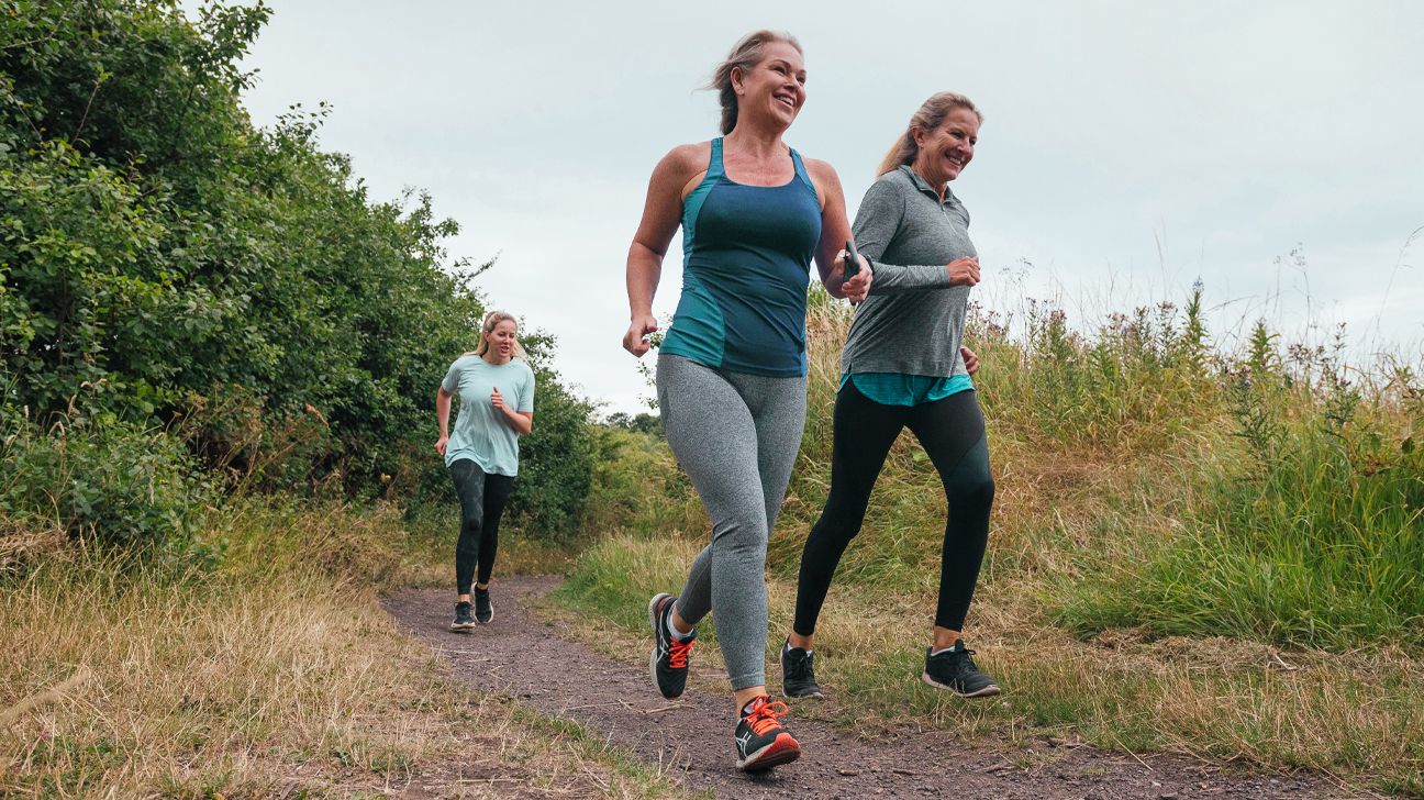 Three women are seen running outside.